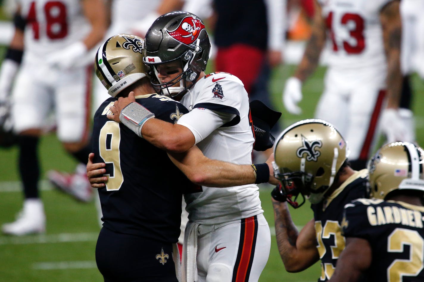 New Orleans Saints quarterback Drew Brees (9) and Tampa Bay Buccaneers quarterback Tom Brady hug after their season opening NFL football game in New Orleans, Sunday, Sept. 13, 2020. The Saints won 34-23. (AP Photo/Butch Dill)