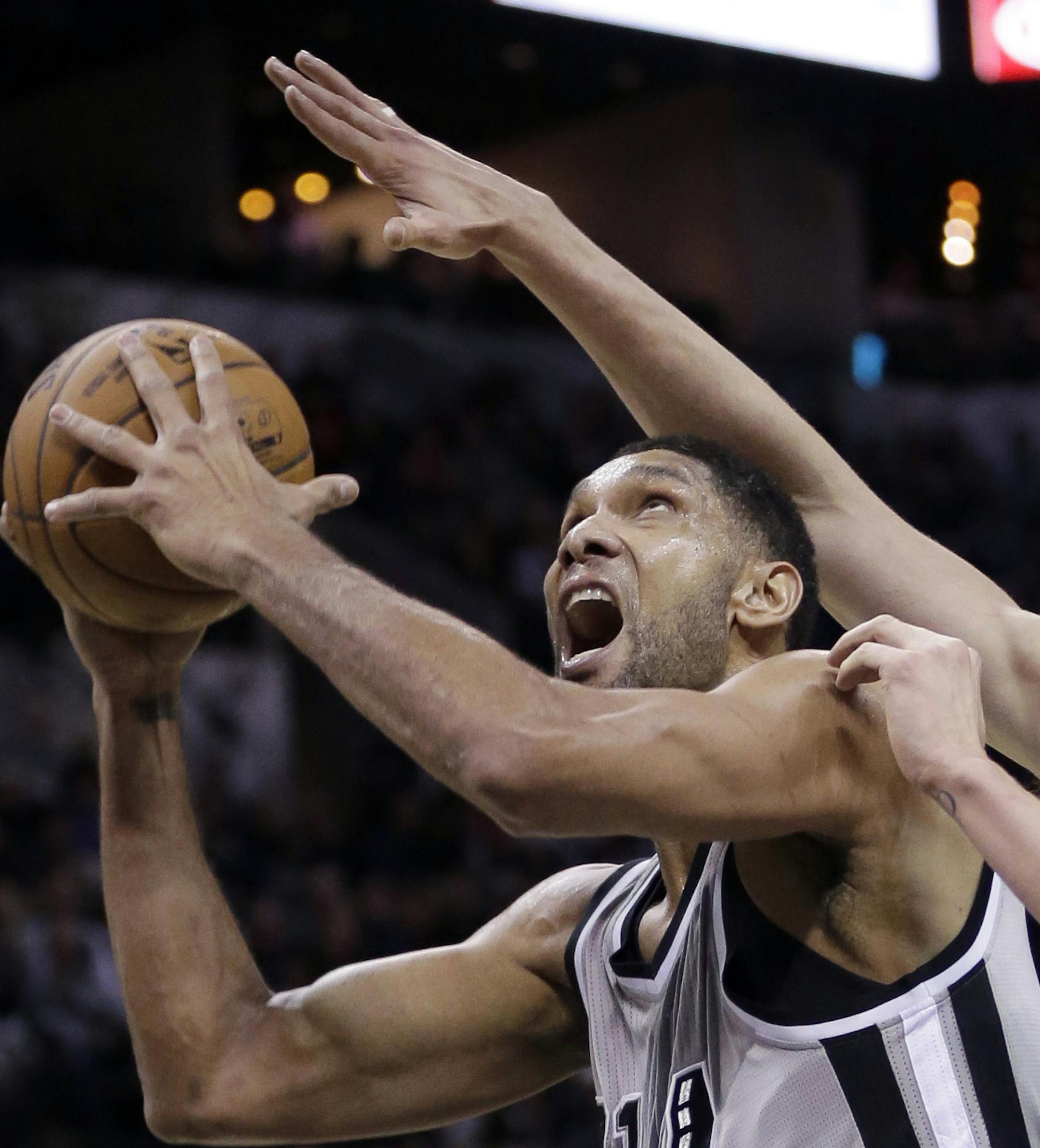 San Antonio Spurs' Tim Duncan, left, shoots around Phoenix Suns' Alex Len, right, during the first half of an NBA basketball game, Friday, Jan. 9, 2015, in San Antonio. (AP Photo/Eric Gay)
