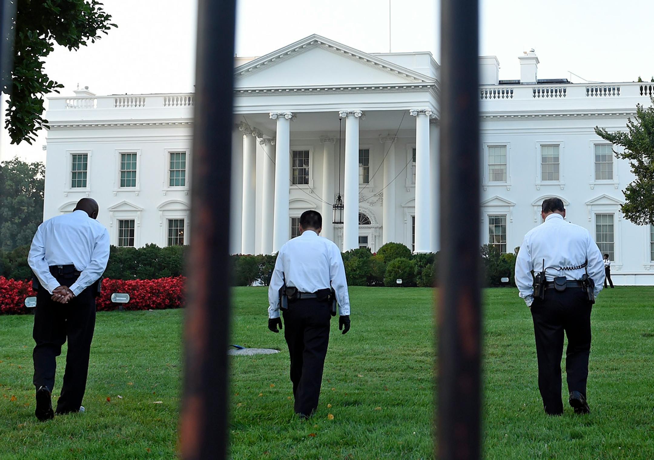 Uniformed Secret Service officers walk along the lawn on the North side of the White House in Washington, Saturday, Sept. 20, 2014. The Secret Service is coming under renewed scrutiny after a man scaled the White House fence and made it all the way through the front door before he was apprehended. (AP Photo/Susan Walsh)