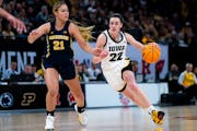 Iowa guard Caitlin Clark plows past Michigan forward Chyra Evans on her way to the basket in the first half of Saturday's Big Ten tournament semifinal