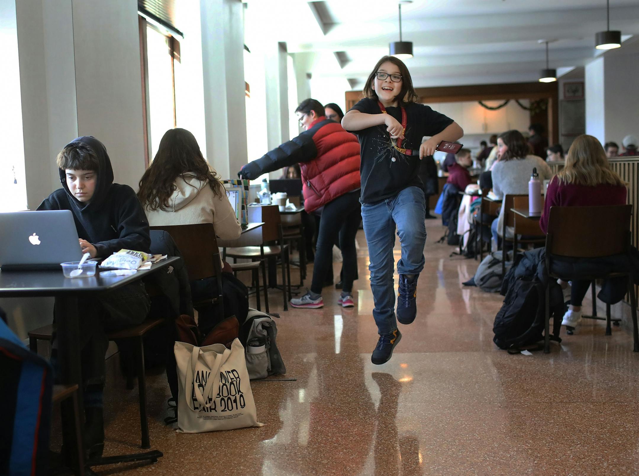 Elliott Tanner, 11, a junior at the University of Minnesota, skips through the Surdyk's Café in Northrup Auditorium where he was having lunch with him mom.