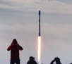 In this view from Playalinda Beach at Canaveral National Seashore, visitors watch a SpaceX Falcon 9 rocket launch from Cape Canaveral Air Force Statio