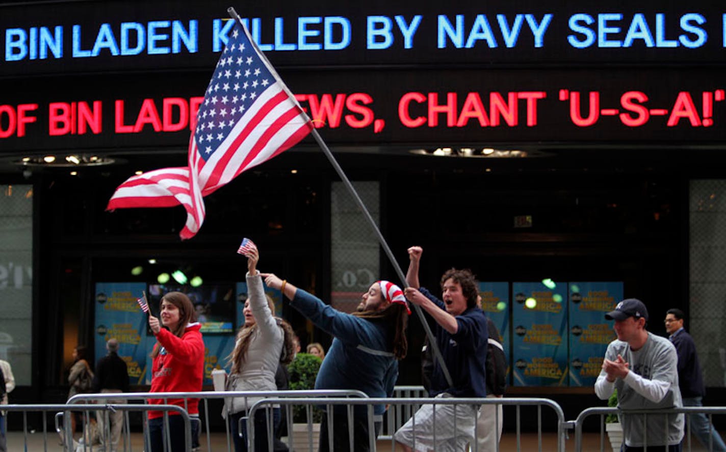 Melissa LaCour, left, Brittany McGarry, second from left, Bryan Murray, second from right, and Dennis Vincent celebrate outside the ABC studio in New York's Times Square as news of Osama bin Laden's death is announced on the ticker, Monday, May 2, 2011.