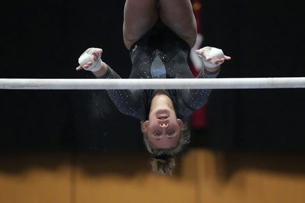 Taylar Schaefer of St. Cloud competes in the uneven parallel bars during the Minnesota State High School League gymnastics championships Saturday, Feb