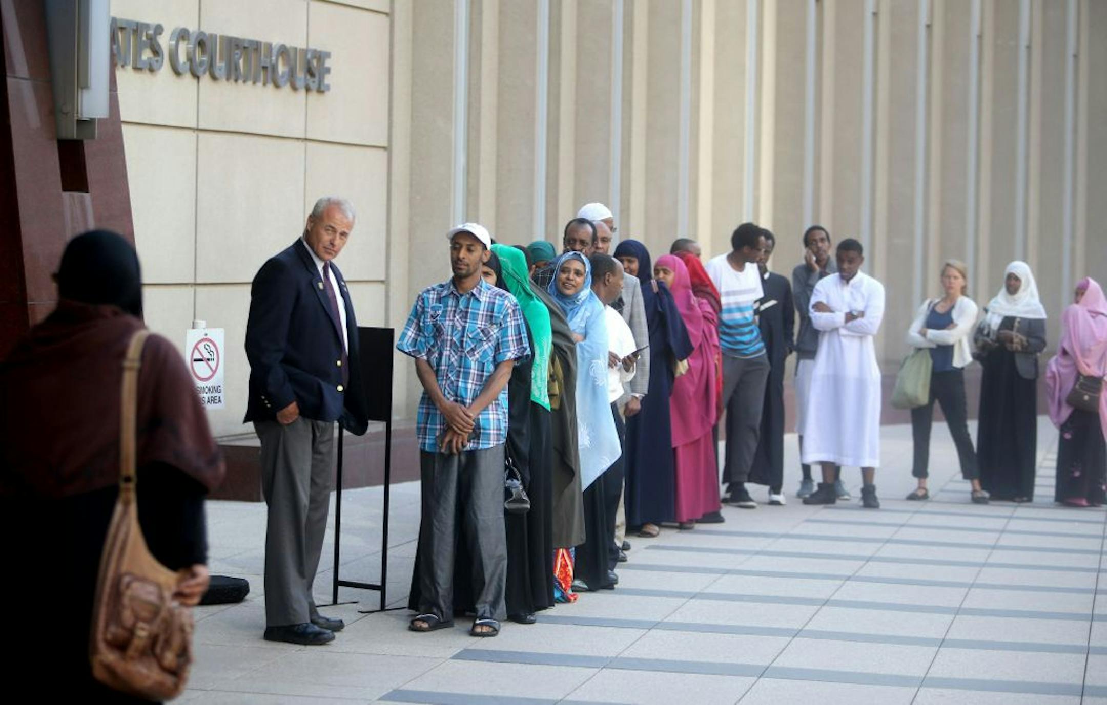 Courtroom observers lined up outside the Federal Courthouse for a spot in the courtroom for a pretrial hearing for three local men accused of conspiring to leave the country to support or join ISIL Wednesday, July 8, 2015, in Minneapolis, MN.