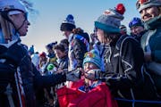 Young fans surrounded skiers like American Rosie Brennan, left, every chance they got, hoping for an autograph or even a coveted piece of equipment.