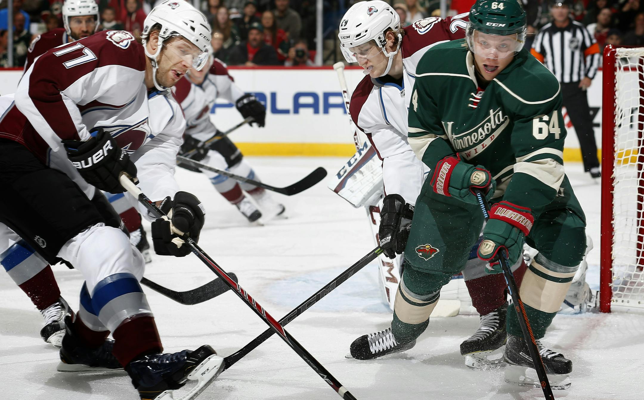 Mikael Granlund (64) and Brad Stuart (17) fought for the puck in the first period.
