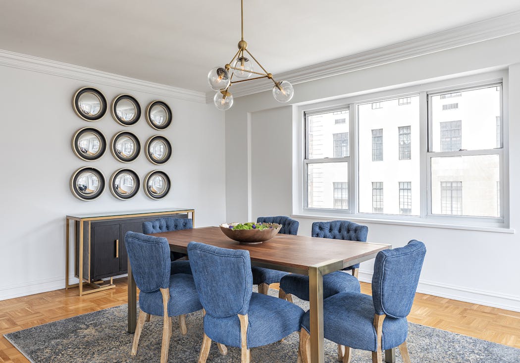 Navy blue dining chairs add an unexpected pop of color to this dining area.