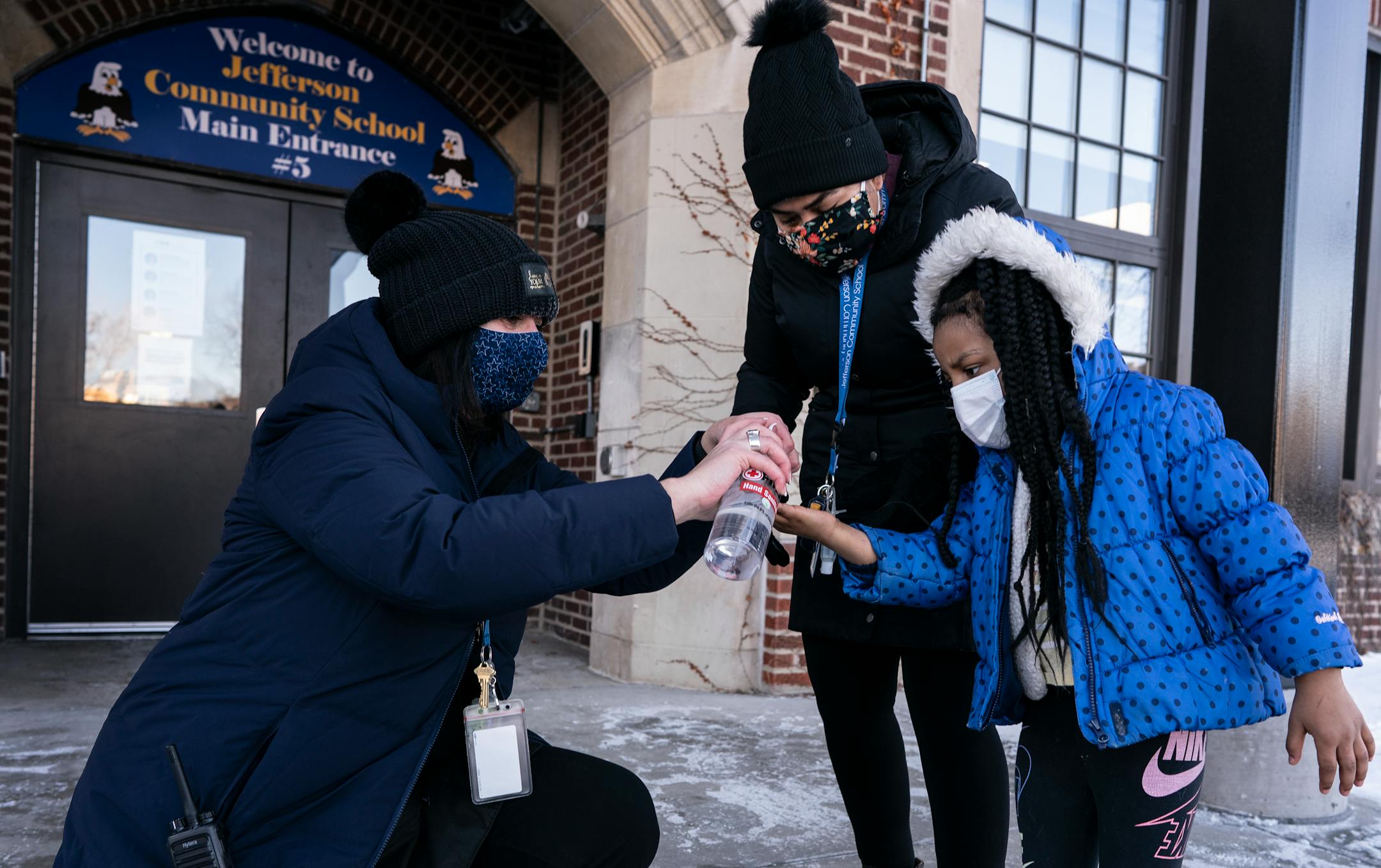 Principal Holly Kleppe left and staff member Gabriela Boley Hernandez applied hand sanitizer in Elizabeth Smith 4, hands before she entered the school Monday February 8, 2021 in Minneapolis.