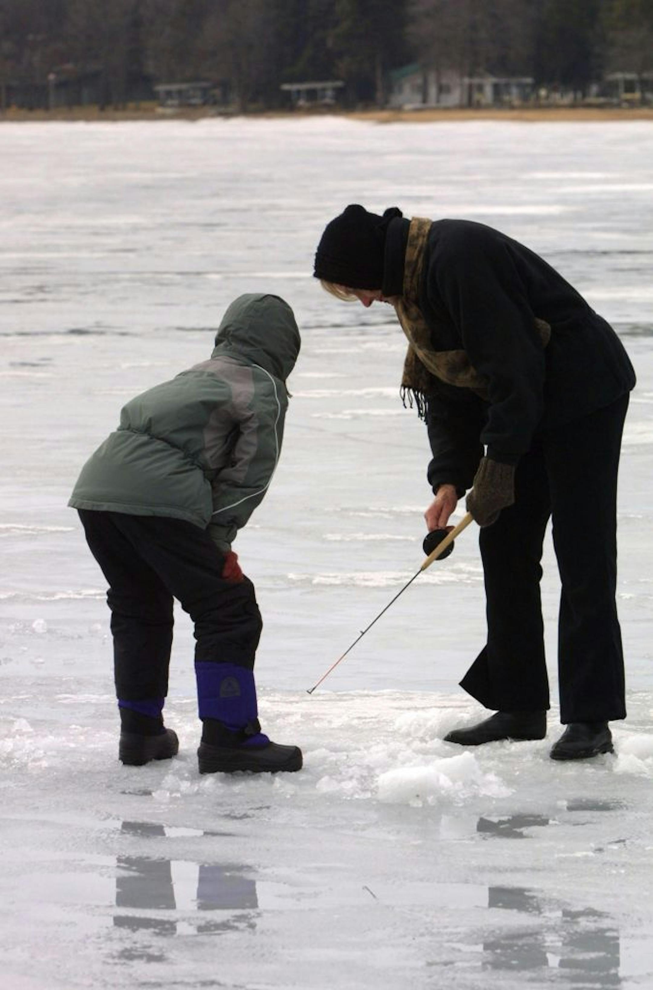 Nisswa, MN Saturday 2/23/2002 Grandparents camp, exploring the mysteries of ice fishing Jan Hively ( right) oof Minneapolis with grandaughter Riley Snider, 8 yrs, from Seattle.