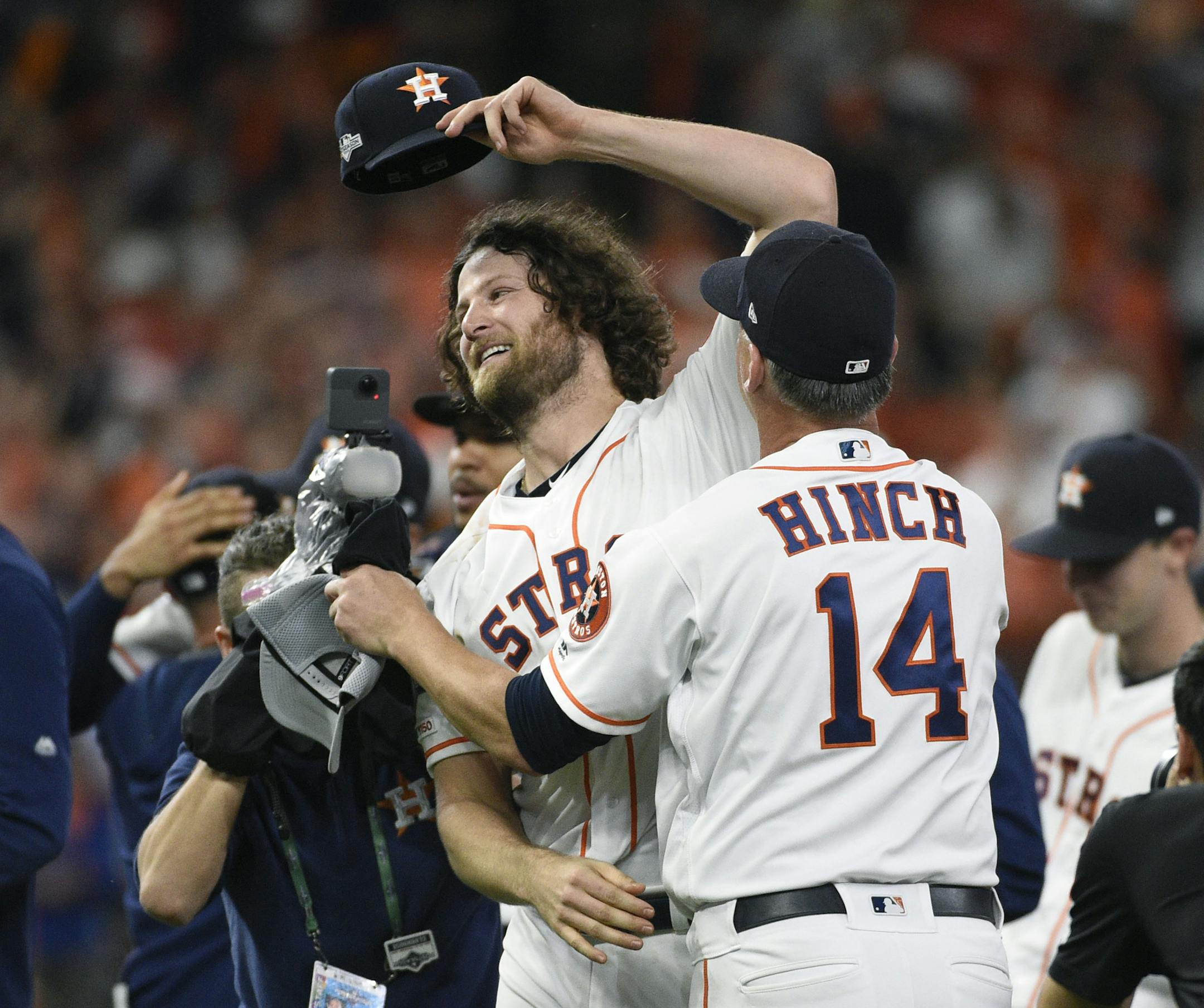 Houston Astros starting pitcher Gerrit Cole (45) celebrates with manager AJ Hinch (14) after the team's win in Game 5 of a baseball American League Division Series against the Tampa Bay Rays in October.