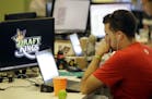 In this Wednesday, Sept. 9, 2015, photo, Devlin D'Zmura, a tending news manager at DraftKings, a daily fantasy sports company, works on his laptop at 