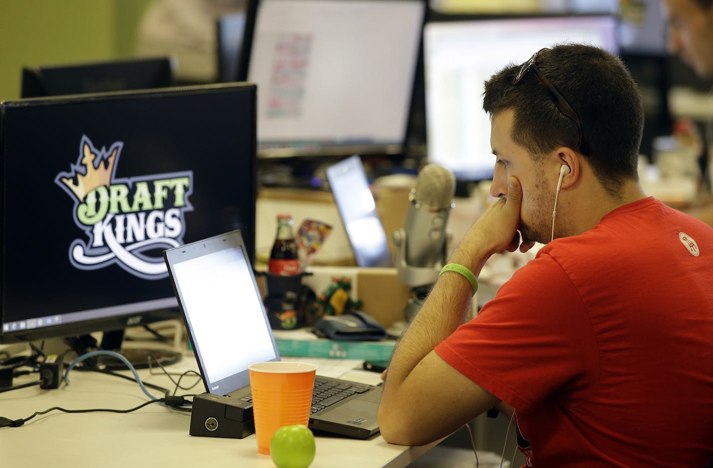 In this Wednesday, Sept. 9, 2015, photo, Devlin D'Zmura, a tending news manager at DraftKings, a daily fantasy sports company, works on his laptop at the company's offices in Boston. The daily fantasy sports industry is eyeing a breakout season as NFL games begin. And its two dominant companies, DraftKings and FanDuel, are touting lucrative opening week prizes to try to draw more customers as more competitors pop up. (AP Photo/Stephan Savoia) ORG XMIT: MIN2015100716085342