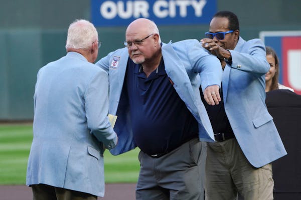 Former Twins manger Ron Gardenhire, center, received a coat from his predecessor, former manager Tom Kelly, left, and Twins great Rod Carew after he w