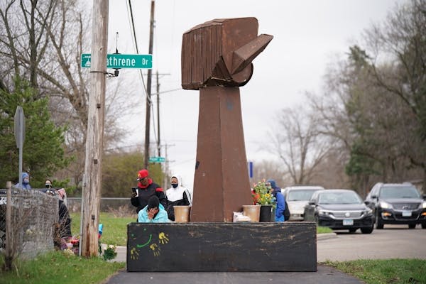 Marissa Tappy prayed Monday afternoon at the base of the fist, first installed at George Floyd Square. ] JEFF WHEELER • jeff.wheeler@startribune.com