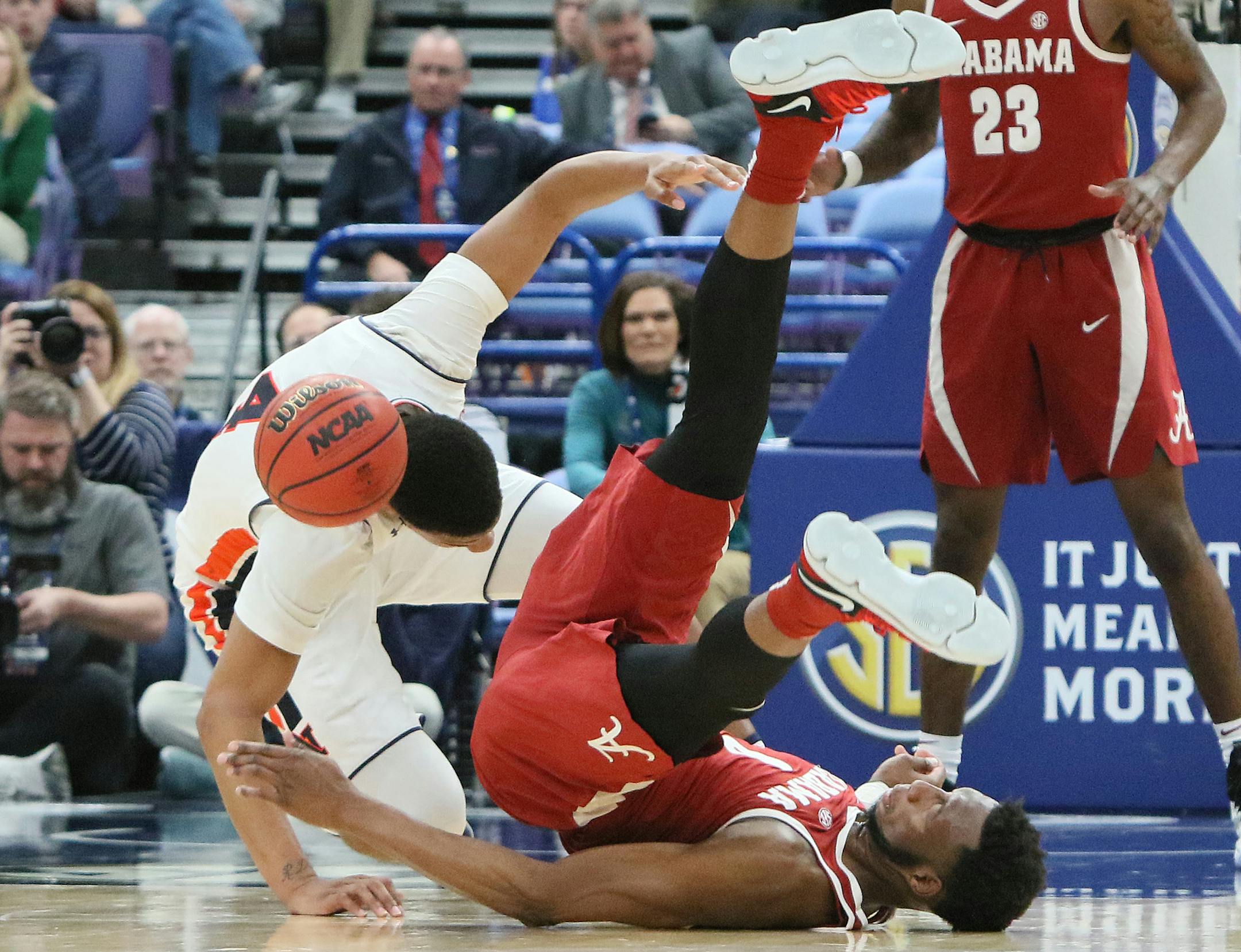 Alabama forward Donta Hall (0) hits the back of his head after tumbling over Auburn forward Chuma Okeke in the second half during an SEC tournament quarterfinal game between Auburn and Alabama on Friday, March 9, 2018, at the Scottrade Center in St. Louis, Mo. (Chris Lee/St. Louis Post-Dispatch/TNS)