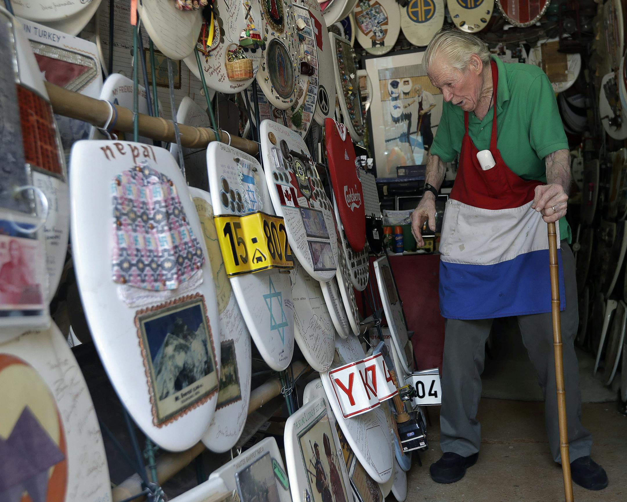 In this Wednesday, May 16, 2018, photo, retired plumber Barney Smith, 96, walks through his Toilet Seat Art Museum in Alamo Heights, Texas. Smith, called "King of the Commode," began his commode art work in 1992 and is looking for a buyer who will preserve his collection intact. (AP Photo/Eric Gay)