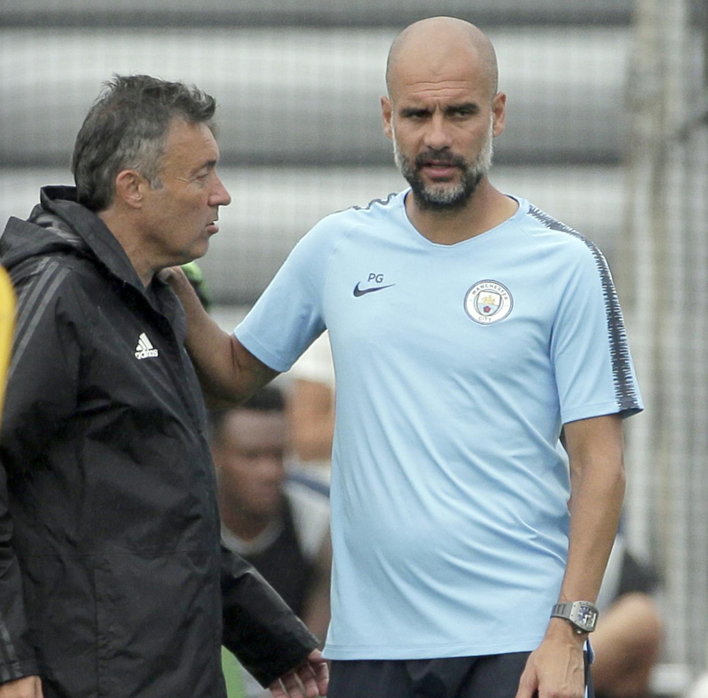 New York City FC manager Domenec Torrent, left, talks with Manchester City FC manager Pep Guardiola during practice for both teams in Orangeburg, N.Y., Monday, July 23, 2018. Manchester City is scheduled to play Liverpool in an International Champions Cup soccer match inNew Jersey on Wednesday, July 25. (AP Photo/Seth Wenig)