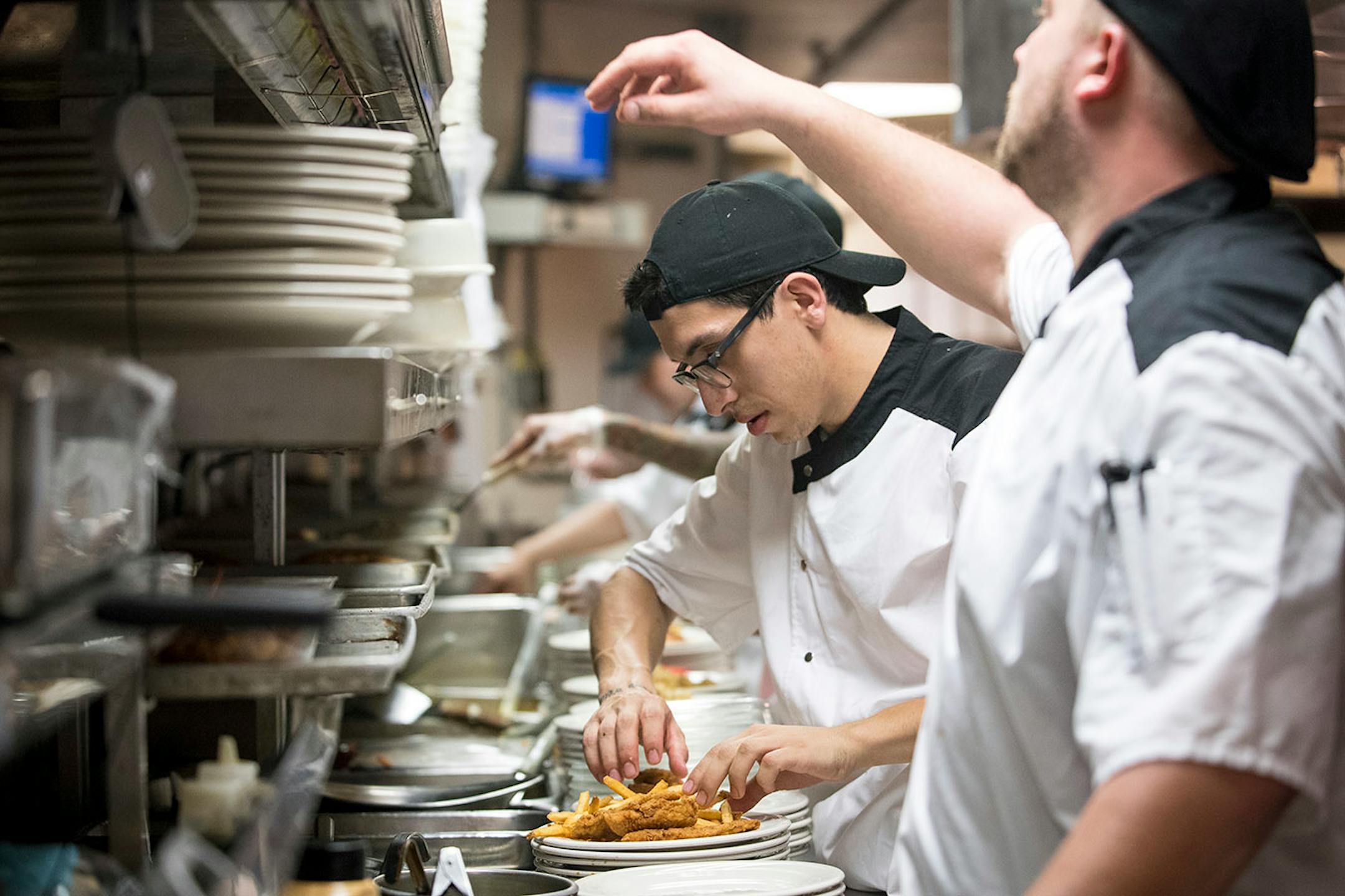 Chef Cesar Pugido, center, plated a dish in the Chanhassen Dinner Theatres' kitchen.