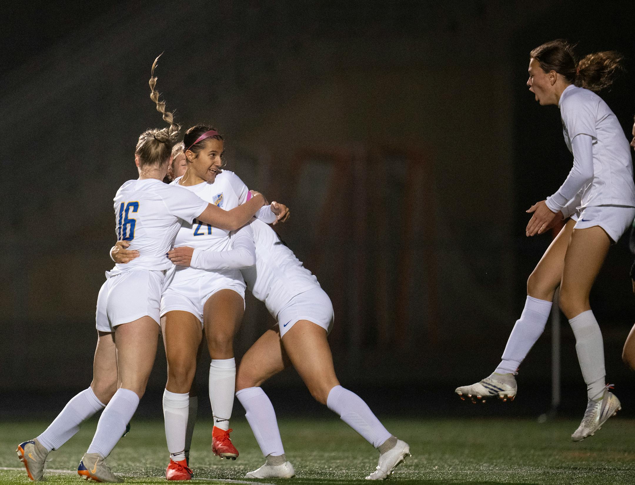 St. Michael-Albertville's Maggie Kramer (21) was congratulated by her teammates after heading in a corner kick in the second half for the first goal of the game.