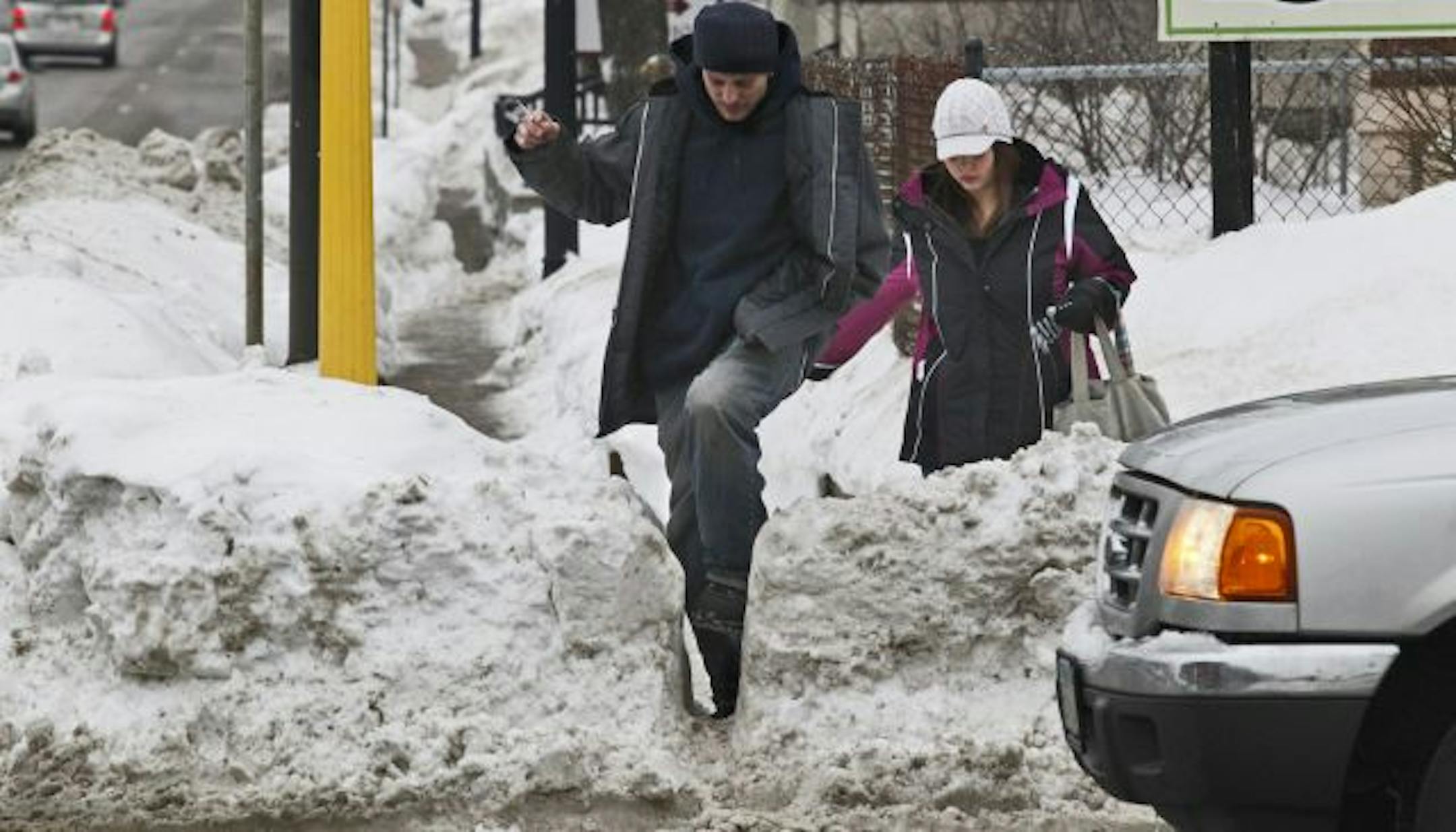 Scott Johnson and Amy Smith took turns squeezing through a breach in a snowbank piled high along Franklin Avenue in Minneapolis.