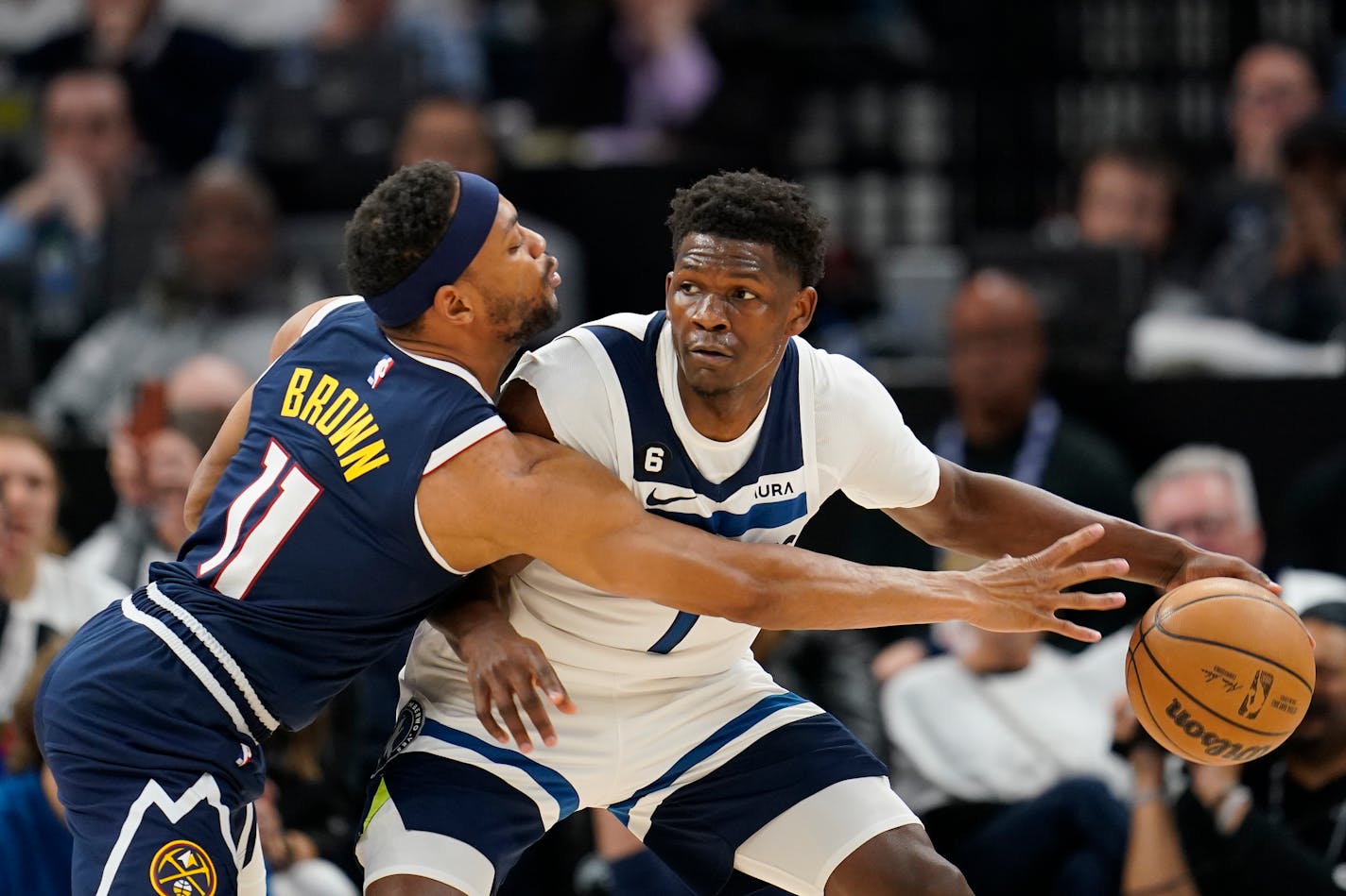 Minnesota Timberwolves guard Anthony Edwards handles the ball while defended by Denver Nuggets forward Bruce Brown (11) during the first half of Game 4 of an NBA basketball first-round playoff series, Sunday, April 23, 2023, in Minneapolis. (AP Photo/Abbie Parr)