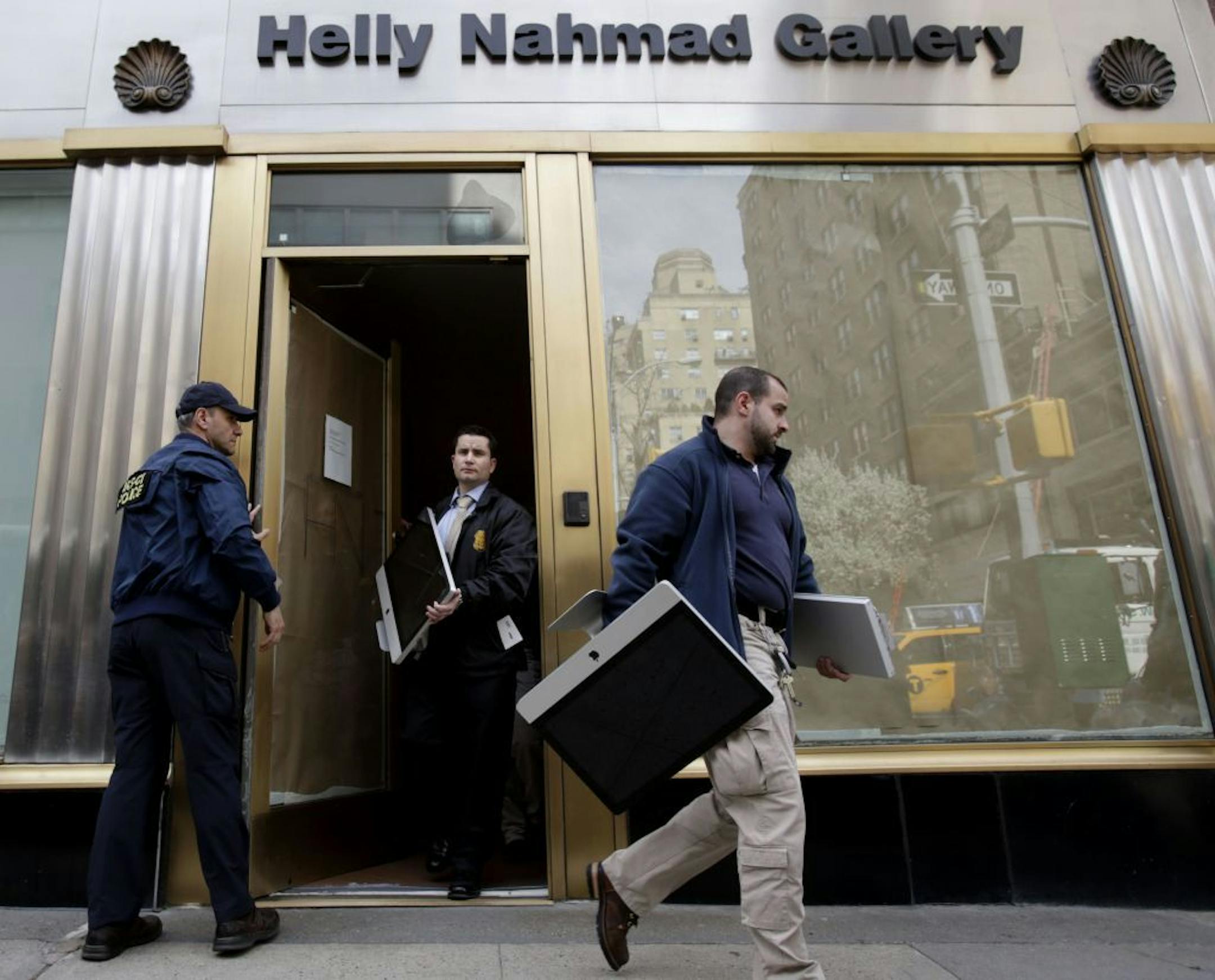 Federal agents remove items, including computers, from an art gallery in New York, Tuesday, April 16, 2013. The agents were raiding the gallery as part of investigation into what Federal authorities in New York say was high-stakes poker games attended by professional athletes, Hollywood celebrities and Wall Street titans, run by members of Russian organized crime.