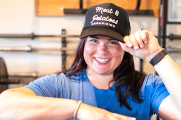 Pictured is Cori McDougald with a hat that says Meat & Potatoes Organizing.