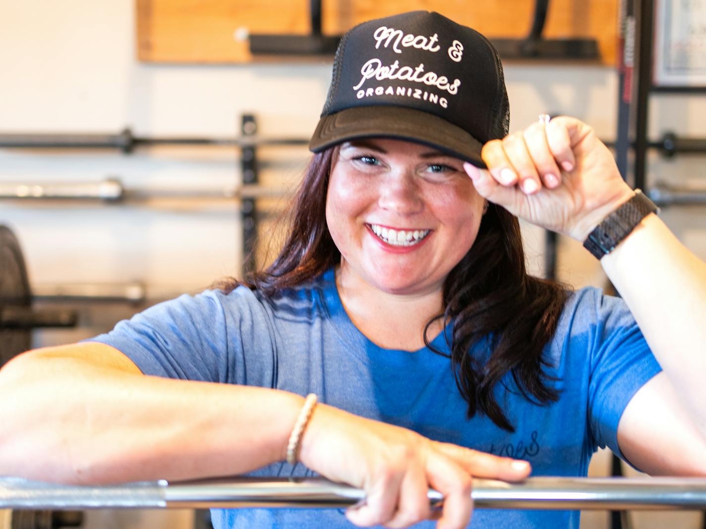 Pictured is Cori McDougald with a hat that says Meat & Potatoes Organizing.