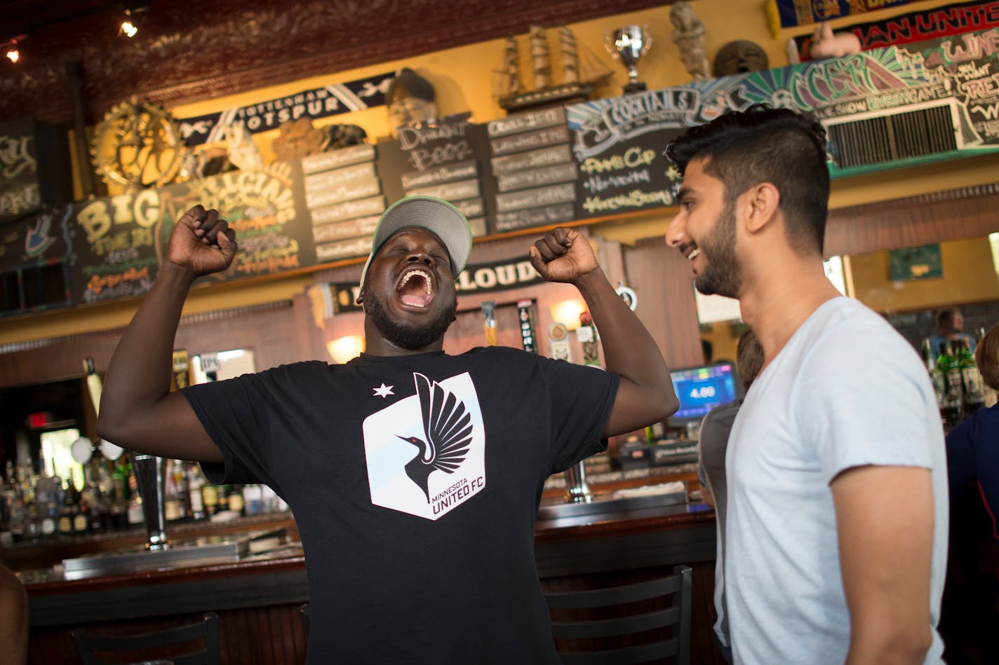 Abraham Opoti, left, of Minneapolis, joked with Dark Clouds organizer Nachiket Karnik at Nomad World Pub before Saturday night's Minnesota United FC game against the Ottawa Fury FC. ] Aaron Lavinsky ¥ aaron.lavinsky@startribune.com Feature on Dark Clouds fan group of Minnesota United soccer. They are a non-stop cheering bunch of soccer nuts who follow the team and support it with non-stop orchestrated cheering at games.