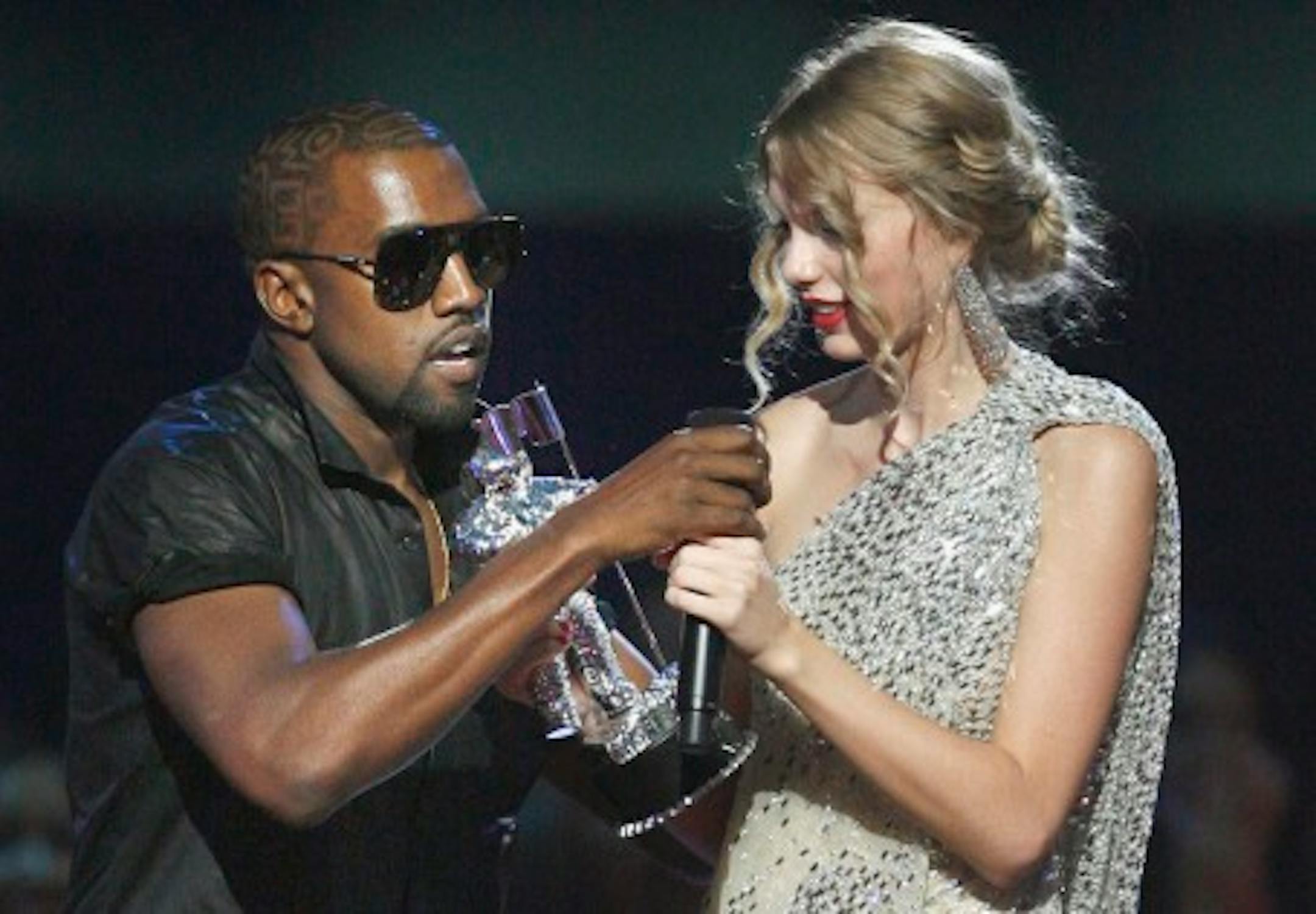 Singer Kanye West takes the microphone from singer Taylor Swift as she accepts the "Best Female Video" award during the MTV Video Music Awards on Sunday, Sept. 13, 2009 in New York.  (AP Photo/Jason DeCrow)