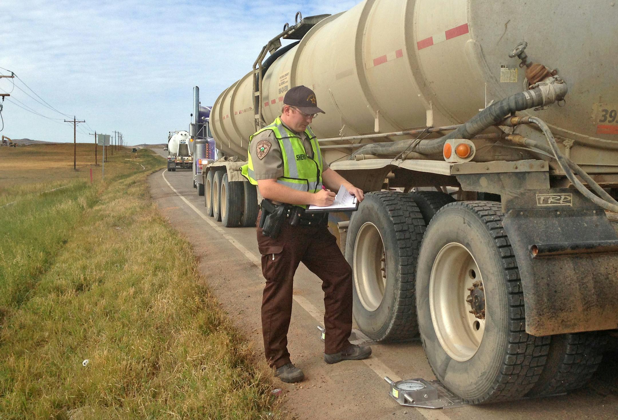 McKenzie County Deputy Sheriff Scott Luman adds up the scales to determine if the truck is overweight. ] Photo credit: Maya Rao - Star Tribune Each oil well in the Bakken relies on 2,300 truckloads to deliver water, sand and other materials to the site, but authorities and researchers estimate that at least one quarter are overloaded, which has prompted over-stressed roads and safety concerns. Trucks that weigh over the limit ‚Äì as high as 105,500 on key roads ‚Ä&#x
