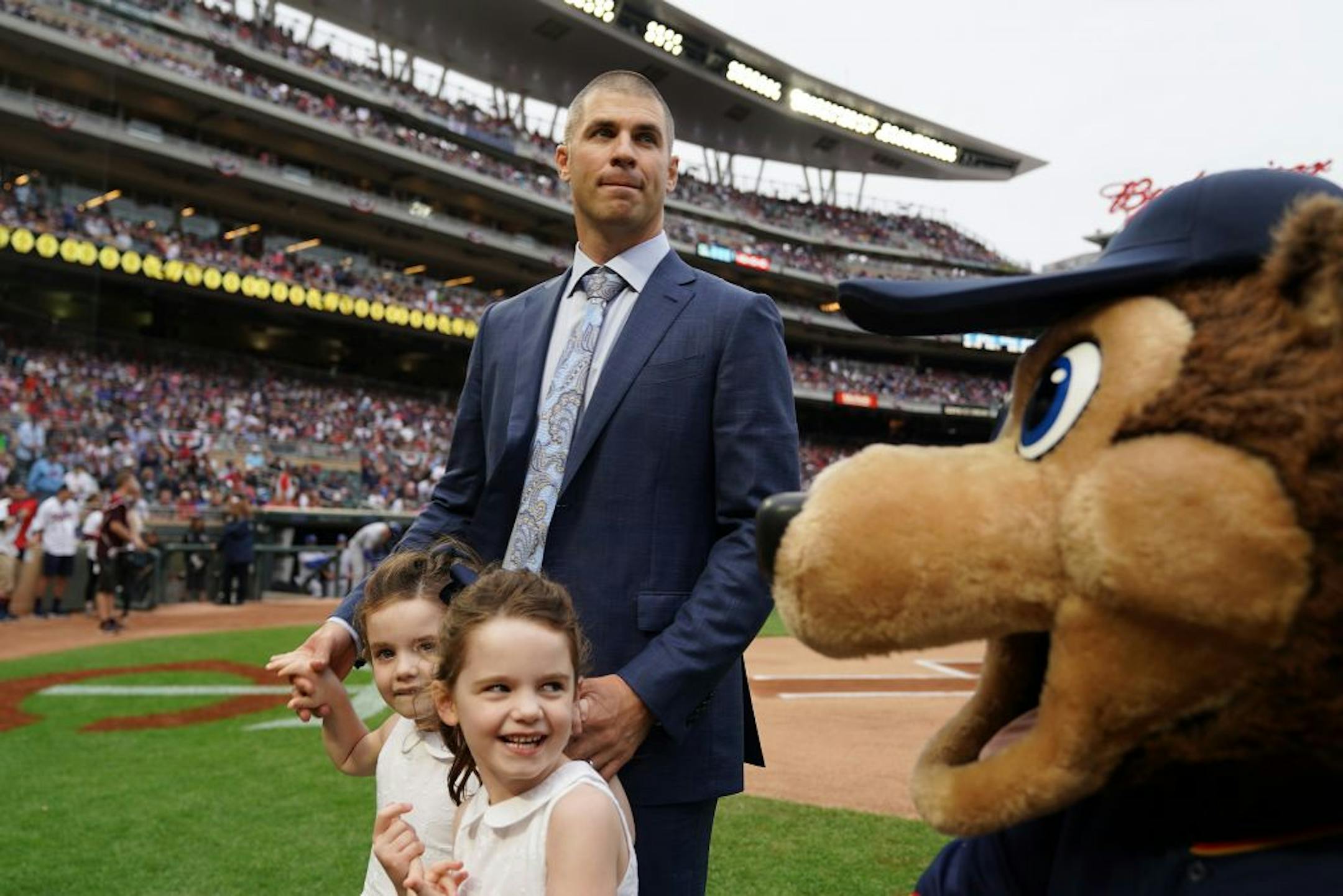 Former Minnesota Twins star Joe Mauer stood on the field with his twin girls following a pregame ceremony to retire his number 7 Saturday.