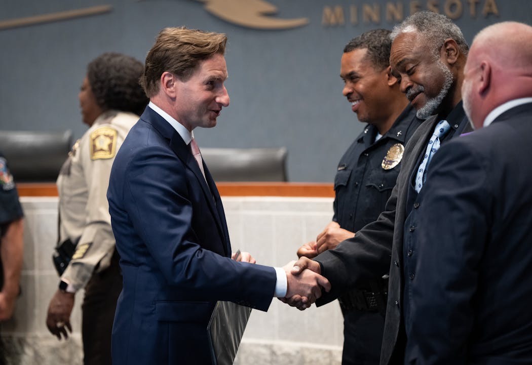 Rep. Dean Phillips shakes hands with Minnesota Public Safety Commissioner John Harrington after speaking at a news conference about his Pathways to Policing Act.