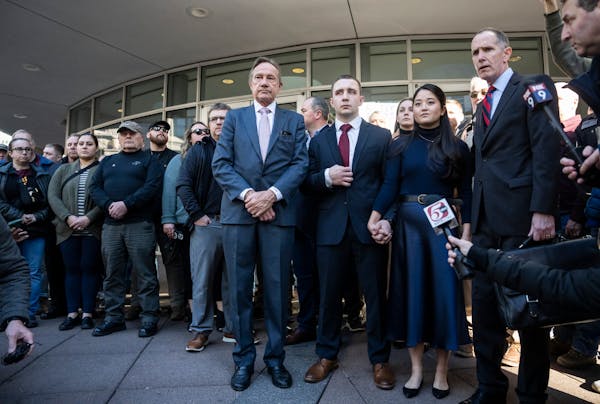 Trooper Ryan Londregan, center in maroon tie, stood with his wife surrounded by security, his lawyers and supporters, including many officers, as his 