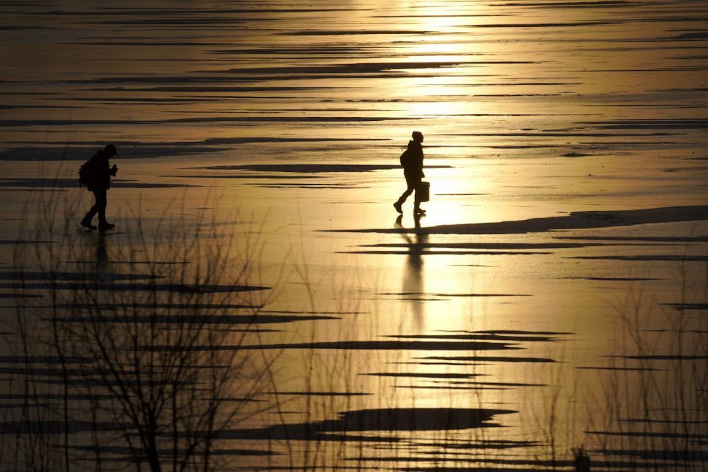 With temperatures climbing into the 40's and potentially breaking records for early January, folks have been flocking outdoors to take advantage of the season. Here on Lake Hiawatha an Ice fishing couple searches for a good spot with the setting sun reflected off the ice.