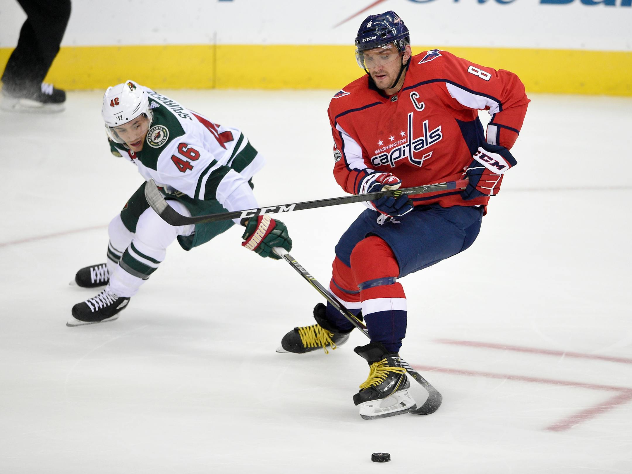 Minnesota Wild defenseman Jared Spurgeon (46) battles for the puck against Washington Capitals left wing Alex Ovechkin (8), of Russia, during the third period of an NHL hockey game, Saturday, Nov. 18, 2017, in Washington. (AP Photo/Nick Wass)