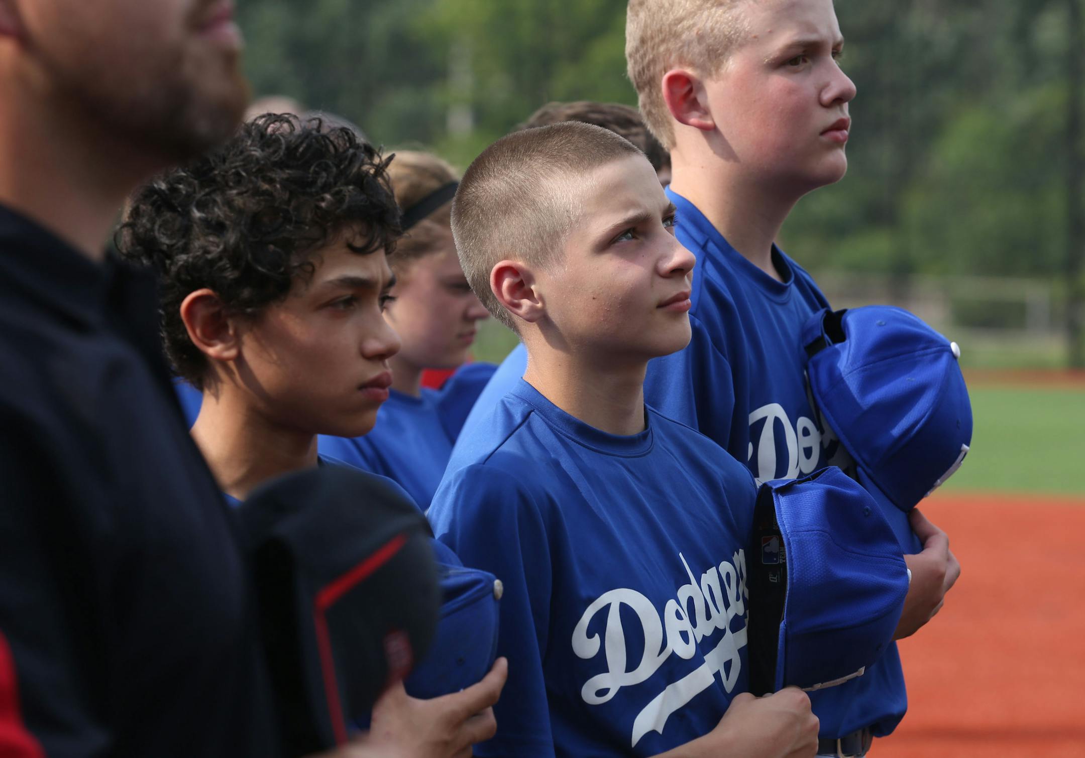 Jared Kula, 13, of the Robbinsdale Dodgers looked up at the flag during the National Anthem before the start of the dedication ceremony. ] (KYNDELL HARKNESS/STAR TRIBUNE) kyndell.harkness@startribune.com At Lee Field in St. Paul, Min. Thursday, July 9, 2014. A baseball field in Robbinsdale has gotten a big upgrade, with a large part of the funding coming from Major League Baseball in conjunction with the All Star game.