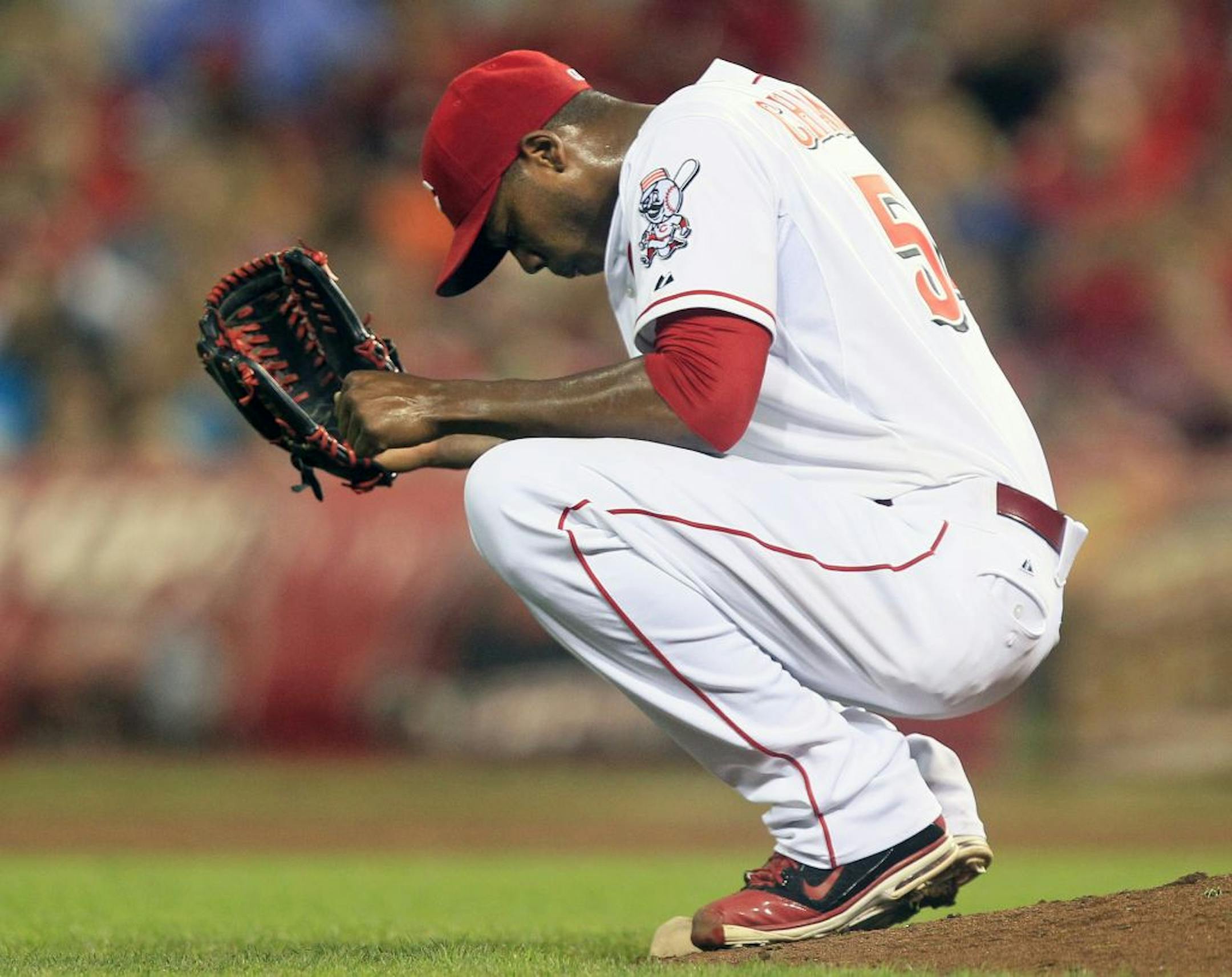 Cincinnati Reds relief pitcher Aroldis Chapman squats behind the mound after giving up a three-run home run to Houston Astros' Matt Dominguez in the ninth inning of a baseball game, Friday, Sept. 7, 2012, in Cincinnati. Houston won 5-3.