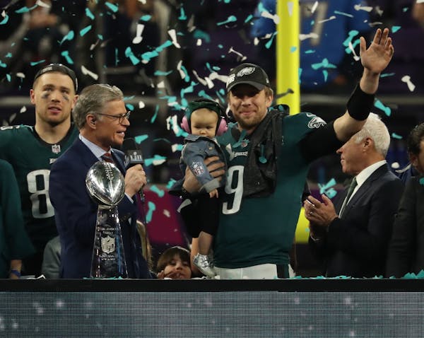 Eagles quarterback Nick Foles held his son and waved during the victory celebration after Super Bowl LII at U.S. Bank Stadium on Sunday.