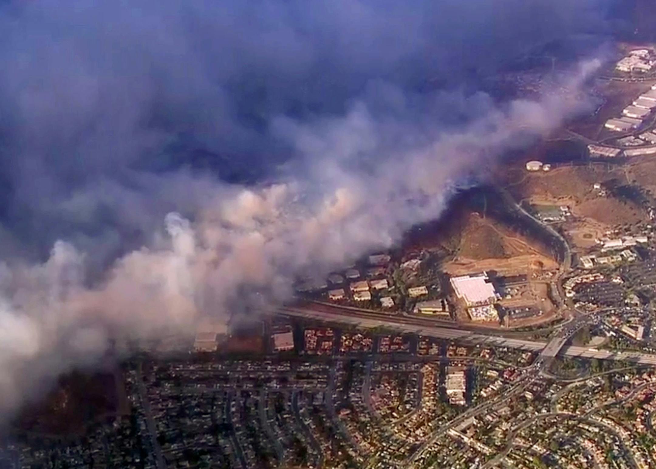 This photo taken from video provided by CBS2/KCAL9 shows a wildfire burning in Camarillo, Calif., Thursday afternoon, Nov. 8, 2018. Known as the Hill fire, it here has crossed U.S. Highway 101, at center right, potentially threatening hundreds of homes. (CBS2/KCAL9 via AP)