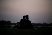 A couple watched the sun set over Crystal Lake Tuesday, May 16, 2023, at Sunset Park in Robbinsdale.