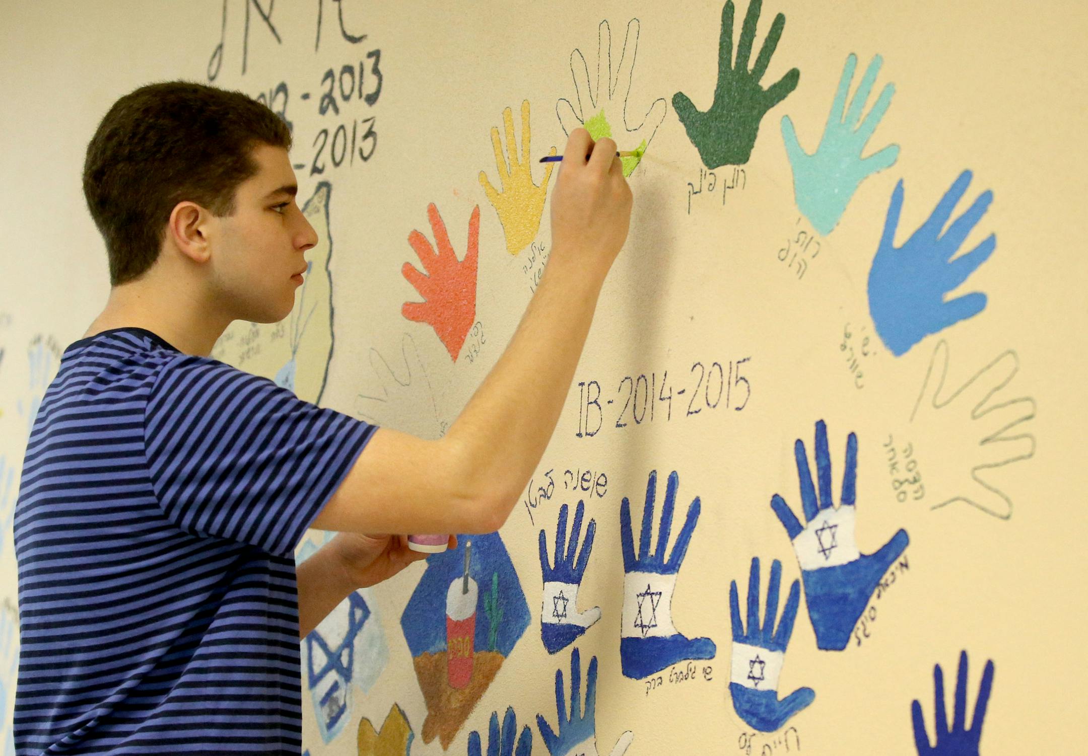 International Baccalaureate Hebrew program junior Sam Orloff paints his hand print on the classroom wall as part of an annual rite of passage for juniors Wednesday, May 5, 2016, at St. Louis Park High School in St. Louis Park, MN.](DAVID JOLES/STARTRIBUNE)djoles@startribune For more than 15 years, St. Louis Park High School has had an International Baccalaureate Hebrew program, one of a handful in the country and the only one in Minnesota.The program is a draw for the city's Jewish community as