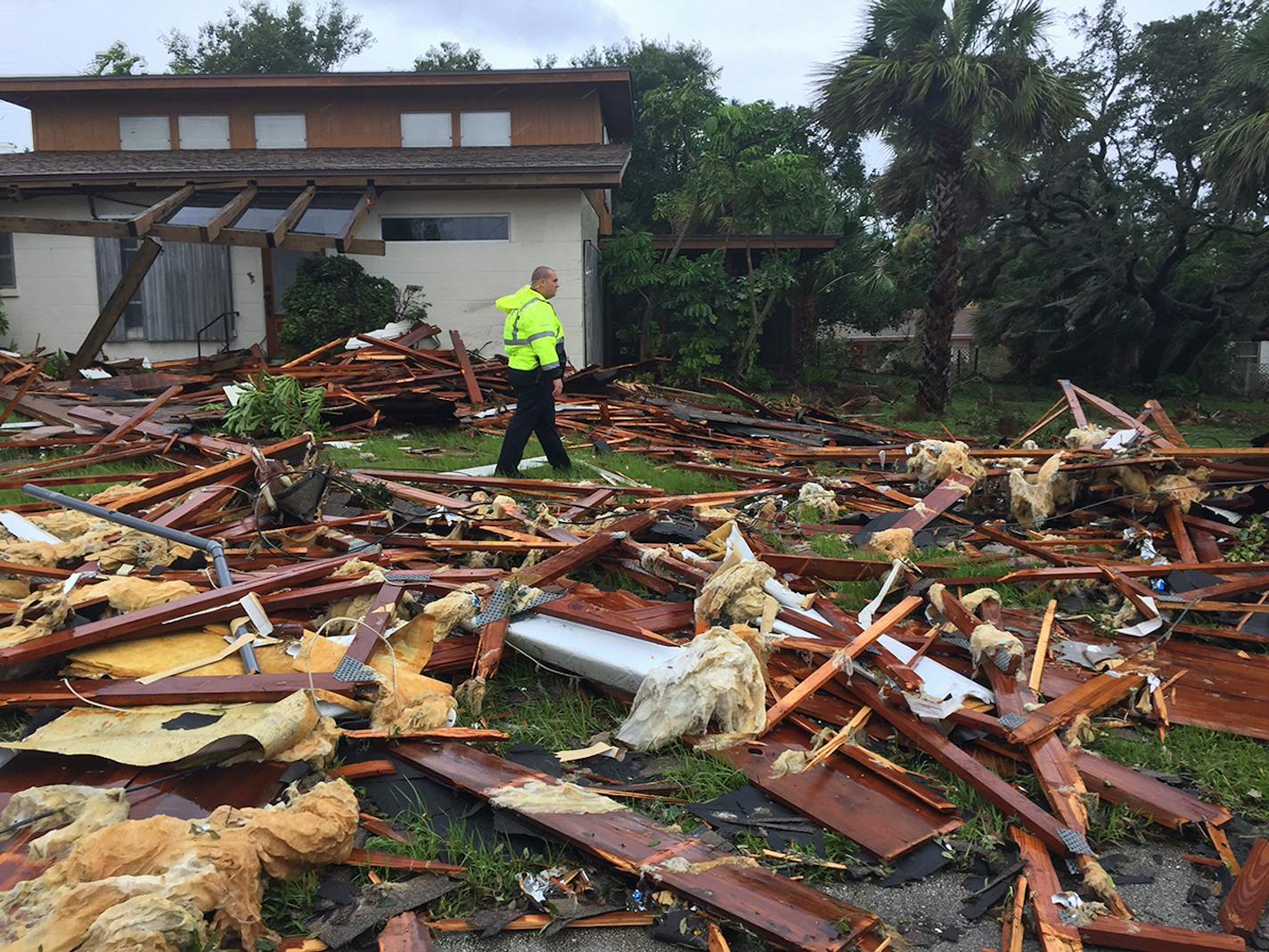 Palm Bay officer Dustin Terkoski walks over debris from a home at Palm Point Subdivision in Brevard County, Florida, after a tornado touched down on Sunday as Hurricane Irma hit.