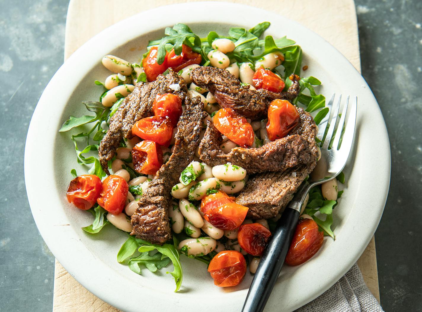 Grilled Steak and White Bean Salad with Blistered Tomatoes is a simple yet classic summer supper. Recipe by Beth Dooley, photo by Mette Nielsen, special to the Star Tribune