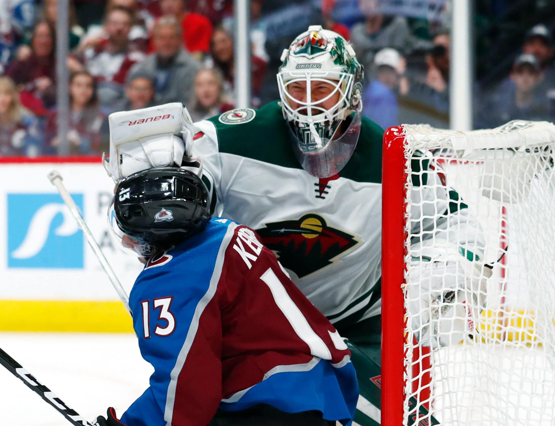 Minnesota Wild goaltender Devan Dubnyk, back, pushes Colorado Avalanche center Alexander Kerfoot out of the crease during the third period of an NHL hockey game Saturday, Jan. 6, 2018, in Denver. The Avalanche won 7-2. (AP Photo/David Zalubowski)