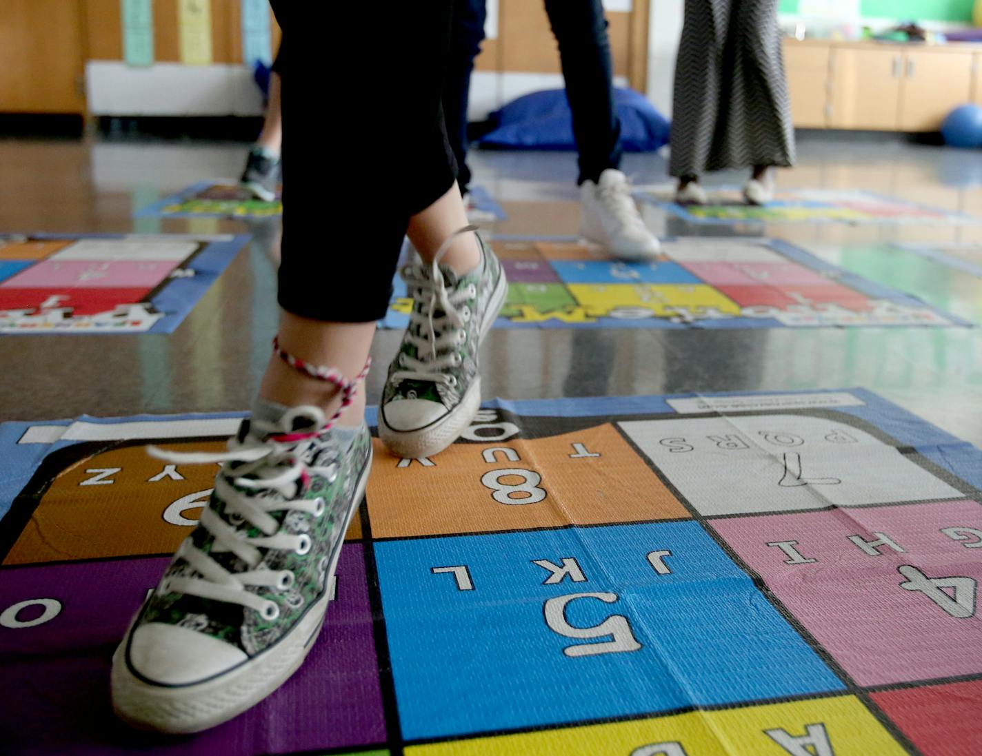 Students in math intervention do multiplication tables on mats to improve skills by moving their feet.