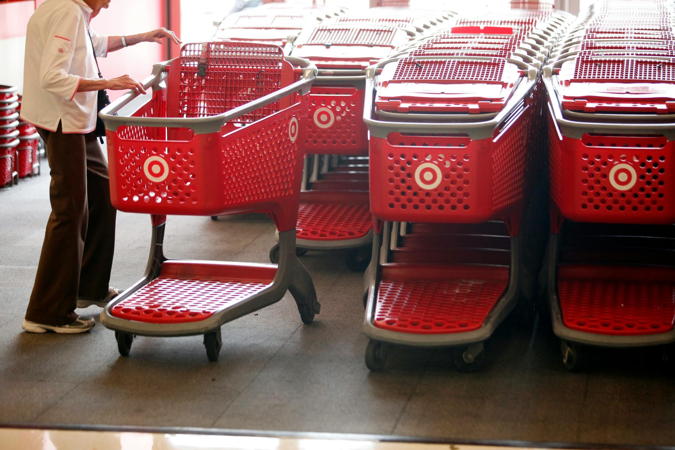 Customers reach for shopping carts inside a Target Corp. store in Torrance, California, U.S., on Tuesday, August 20, 2013. Target is expected to announce quarterly earnings results on Aug. 21, 2013. Photographer: Patrick T. Fallon/Bloomberg