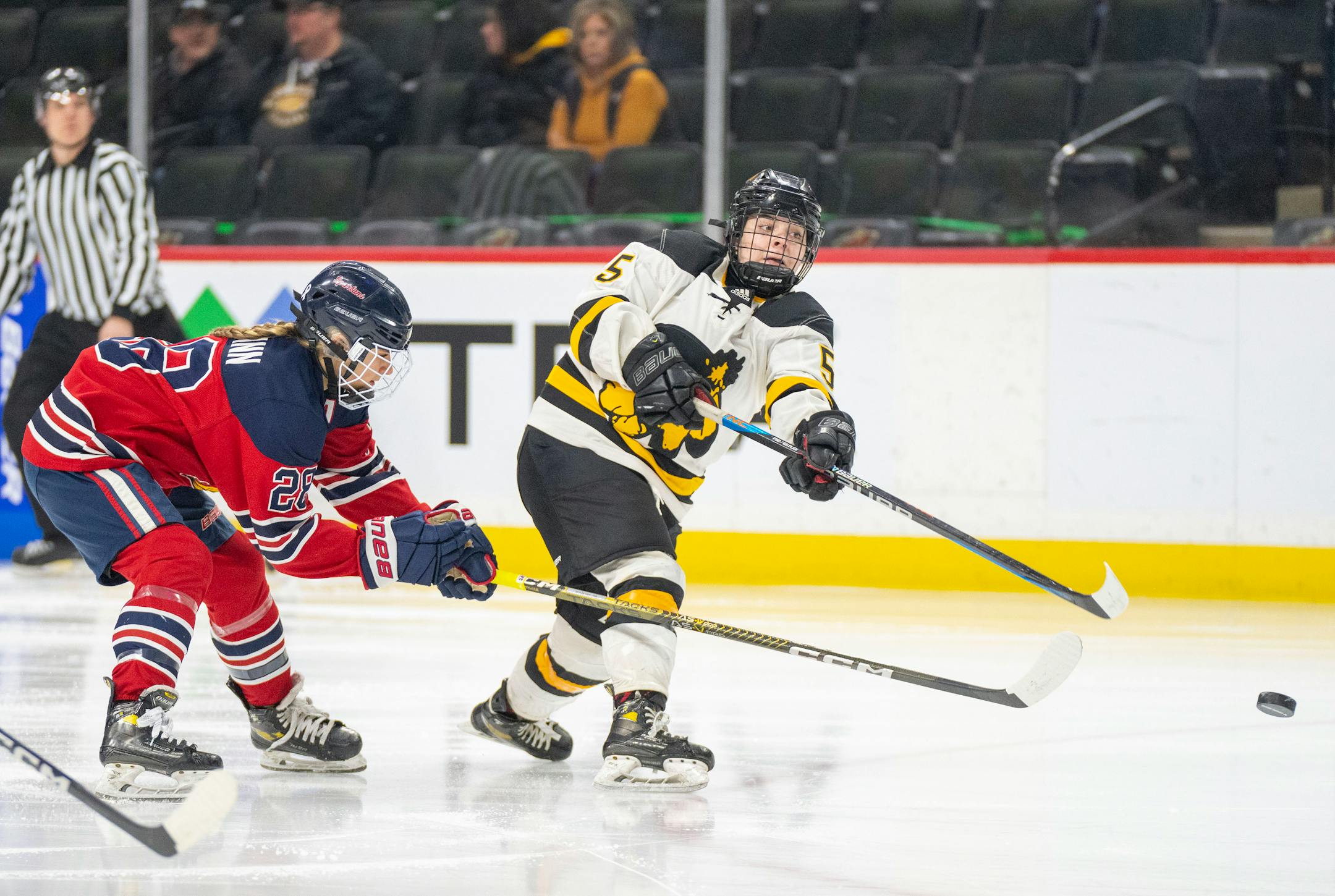 Warroad forward Lila Lanctot (55) takes a shot while being defended by Orono defenseman Allie Pleimann (28) during the first period.
