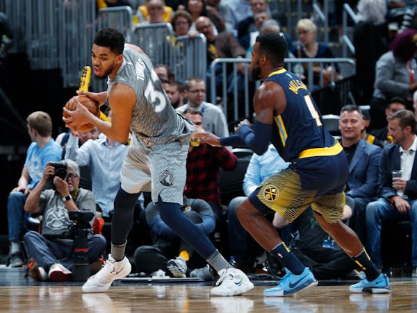 Timberwolves center Karl-Anthony Towns, left, is defended by Denver Nuggets forward Paul Millsap during the second half last week.